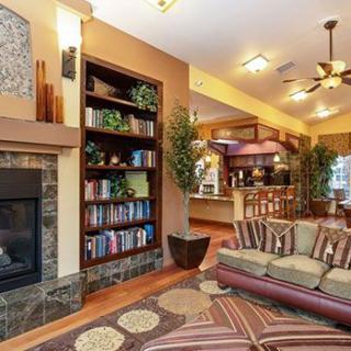 A cozy living room with a fireplace, bookshelves, and comfortable seating in an open floor plan.