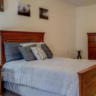 A cozy bedroom with a neatly made bed and wooden furniture.