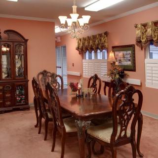 A traditional dining room with elegant furniture and warm lighting.
