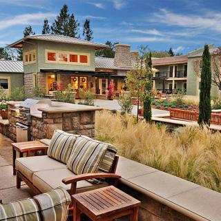 A luxurious modern home with beautifully landscaped gardens and outdoor seating.