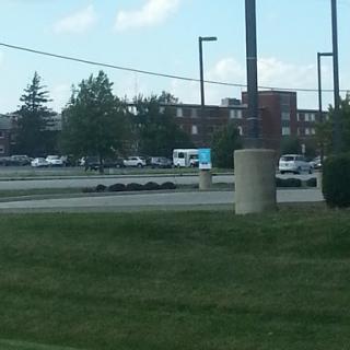 A view of a parking lot with buildings in the background and some vehicles.