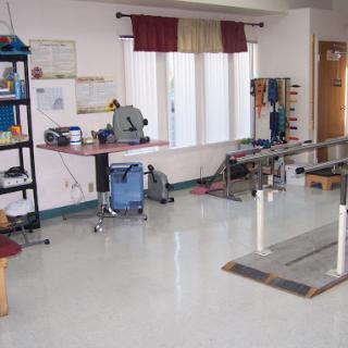 A well-equipped physical therapy room featuring rehabilitation equipment and a workstation.