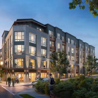 A modern residential apartment building in an urban setting during the evening.