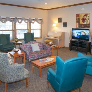 A cozy living room with comfortable seating, a television, and a piano, creating an inviting atmosphere for relaxation.