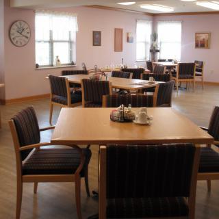 An empty dining room with neatly arranged tables and chairs.