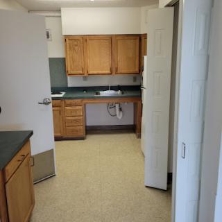 A spacious kitchen with wooden cabinets and a clean, open layout.