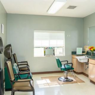 A bright and tidy hair salon with a waiting area and salon chair.