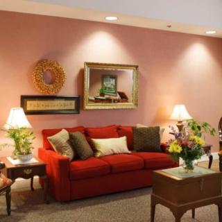 A cozy living room with a red sofa, warm lighting, and decorative accents.