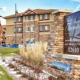 Exterior view of a hotel with adjacent signage and well-maintained landscaping.
