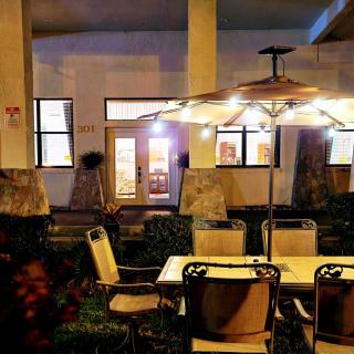 Cozy outdoor patio seating area illuminated by warm lights.