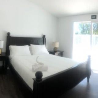 A bright and minimalist bedroom with a large bed and natural lighting.