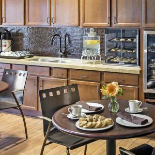 A cozy kitchen setup with a breakfast table featuring coffee and croissants.