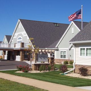 A residential building with a well-maintained lawn and an American flag flying in front.