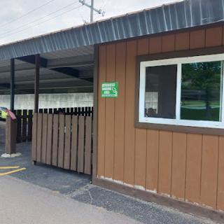 Exterior view of a building with wooden siding and a fenced entrance.