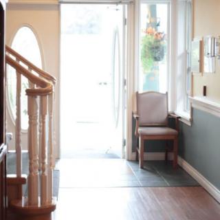 A bright entrance area with a chair by the window and a staircase leading upstairs.