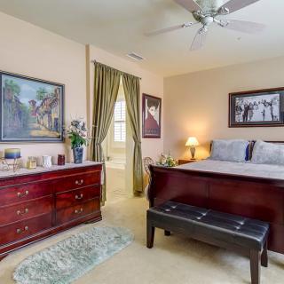 A cozy bedroom with classic furniture and decorative artwork on the walls.