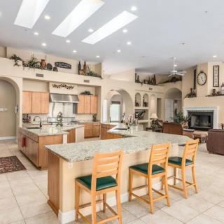 A spacious and modern kitchen with an open floor plan, featuring a large island and seating.