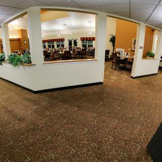A spacious dining area featuring tables, chairs, and decorative plants.