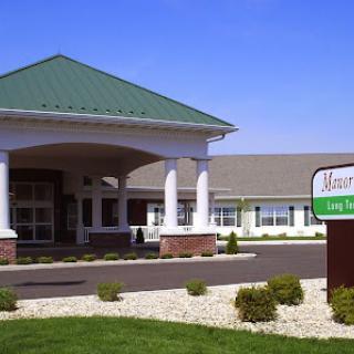 A welcoming entrance to a senior living facility with well-maintained landscaping.