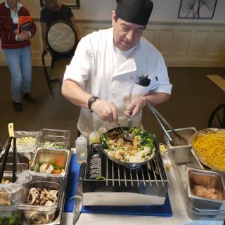 A chef skillfully preparing a dish in a bustling kitchen environment.
