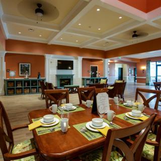 A well-decorated dining room featuring neatly arranged tables with place settings, warm lighting, and elegant interior decor.