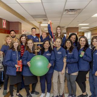 A group of people in uniform posing indoors, showcasing teamwork and community spirit.