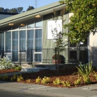 A modern building with large windows and well-maintained landscaping.