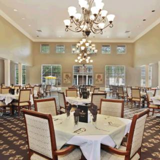 An elegant dining room with chandeliers and neatly arranged tables and chairs.