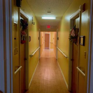 A well-lit hallway with yellow walls and decorated doors.