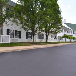 A quiet suburban street lined with trees and houses.