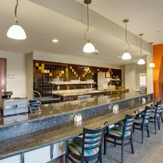 A modern restaurant bar featuring a sleek granite countertop and stylish seating.