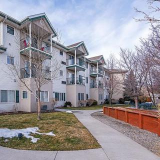 A residential apartment building with a tidy sidewalk and bare winter trees.