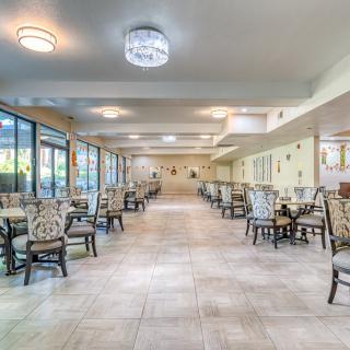A spacious and elegantly designed dining area with neatly arranged tables and chairs.