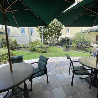 An inviting patio with shaded outdoor seating surrounded by a lush garden.