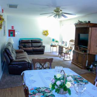 A cozy living room with a dining area, featuring comfortable seating and a TV.