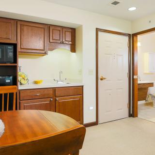 A compact kitchen with wooden cabinets and a small dining area.
