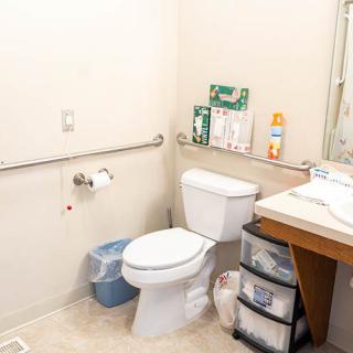 A small bathroom with a toilet, sink, and various toiletries.