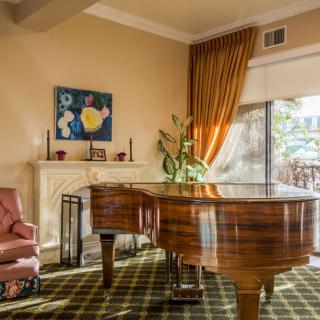 A cozy living room with a grand piano and elegant decor.