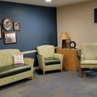A cozy waiting room with armchairs, a sofa, and wall decor.
