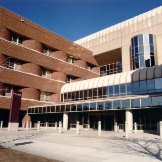 A modern architectural building with brick and glass elements.