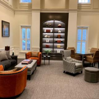 A cozy lounge area with comfortable seating and a modern bookshelf.