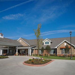 A residential building with a landscaped entrance and a clear blue sky.