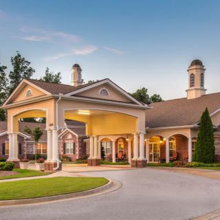 A well-maintained building with a welcoming entrance and landscaped surroundings under a clear blue sky.