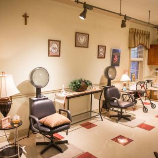 A cozy salon interior with hair dryers, chairs, and warm decor.