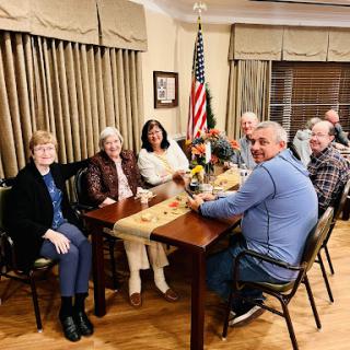 A group of friends gathered for a meeting around a table, sharing moments and conversations.