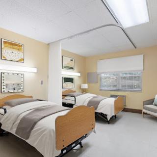 A well-designed hospital patient room featuring two adjustable beds and a calming color scheme.