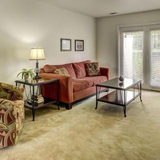 A cozy living room with a red sofa and glass coffee table.