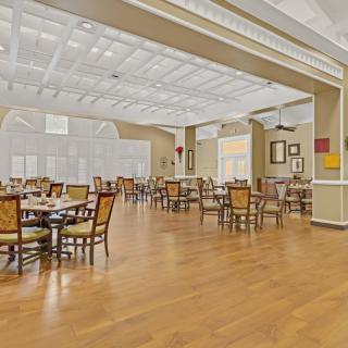 A spacious and bright dining area with neatly arranged tables and chairs.