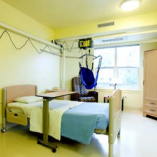 A hospital room with a bed and medical equipment.