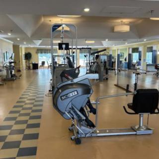 A spacious gym with various exercise machines and equipment.